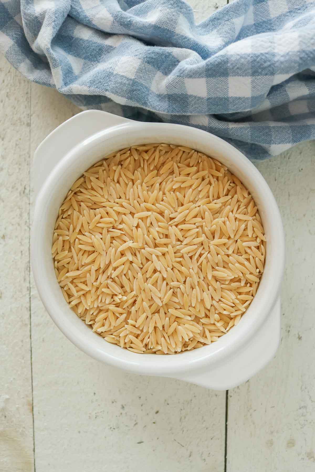 Uncooked orzo pasta in a bowl.