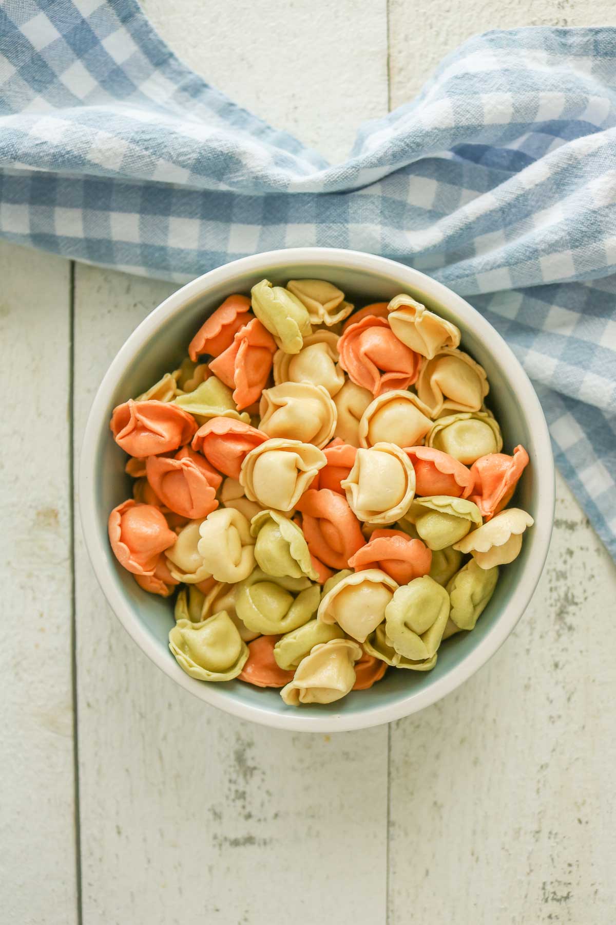 Uncooked store-bought cheese tortellini in a bowl.