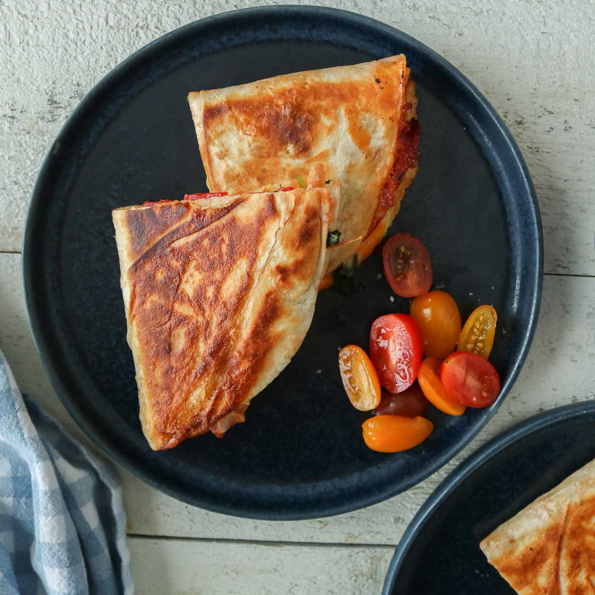 Plated quesadillas with grape tomatoes.