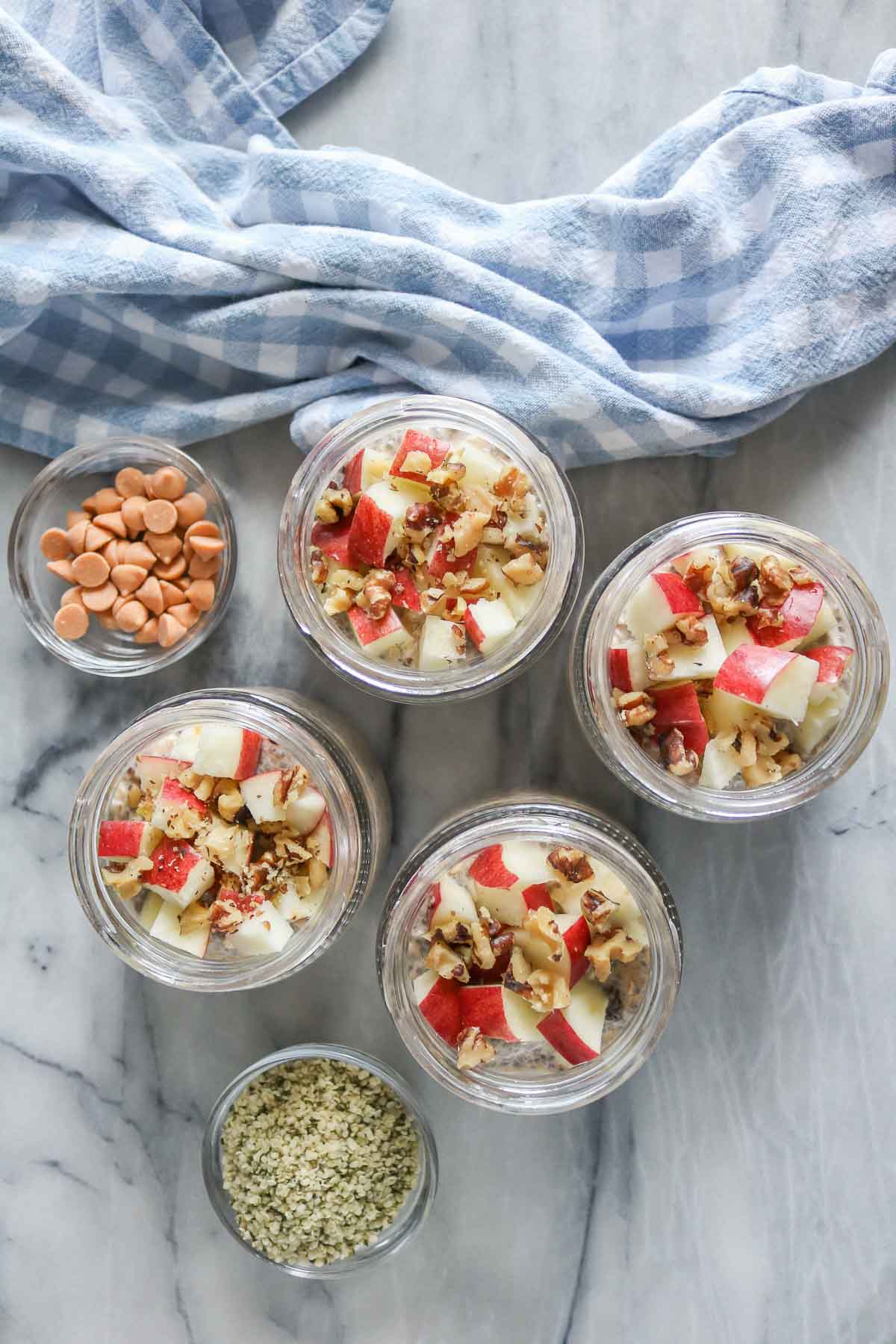 Four jars of overnight oats with toppings.