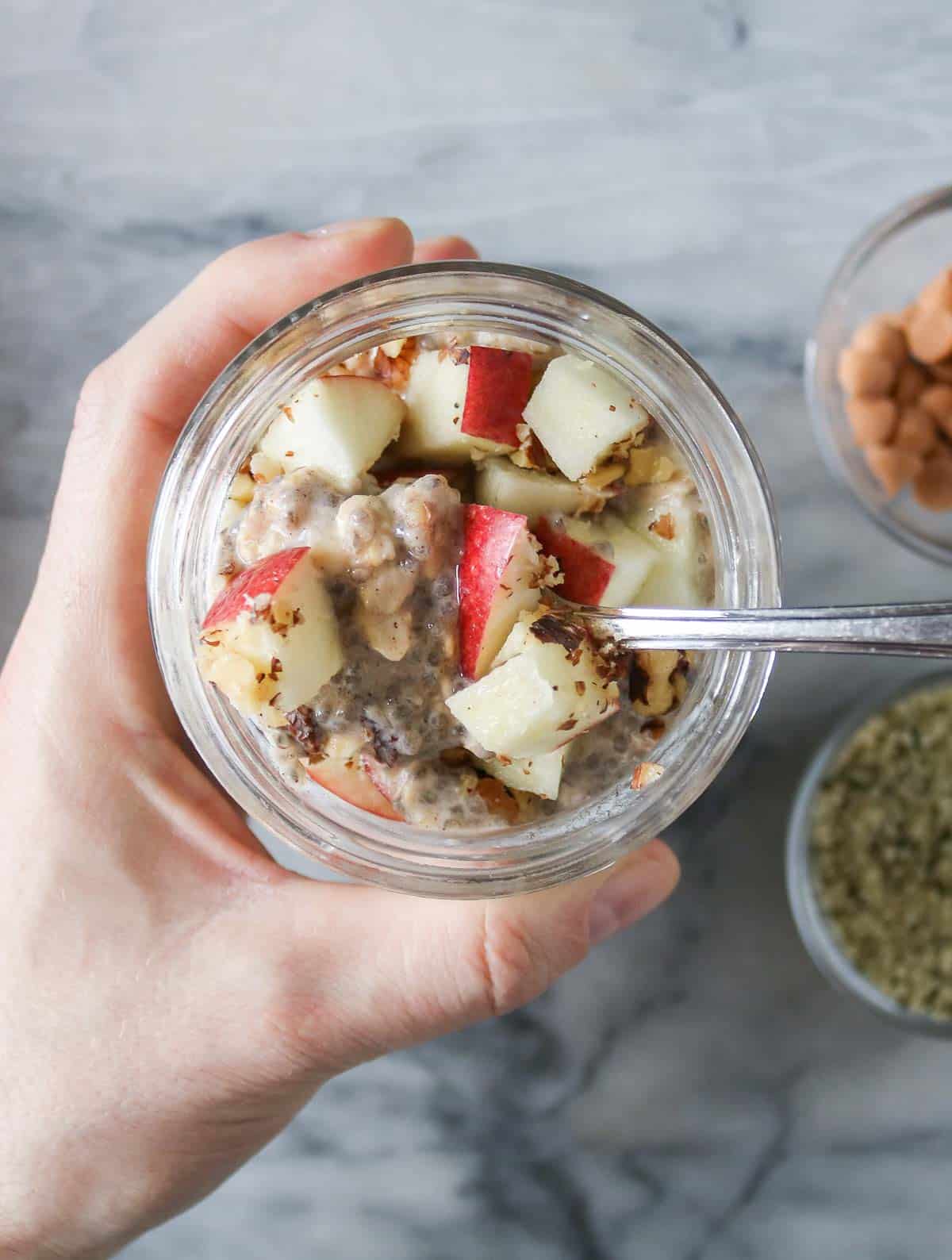 Hand holding a jar of overnight oats.