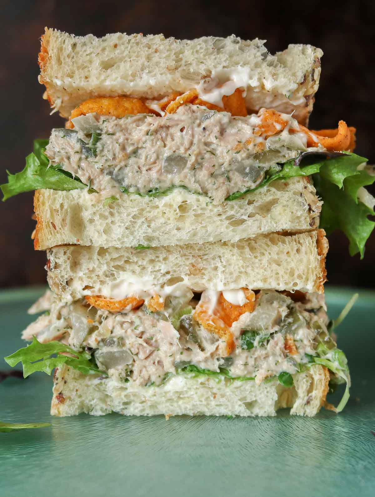 Stack of two halves of a dill pickle tuna salad sandwich.