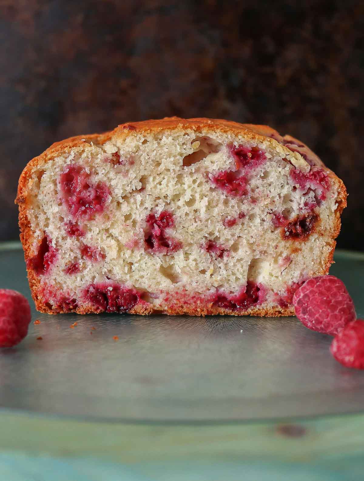 Loaf of raspberry lemon bread that has been cut, showing the interior.