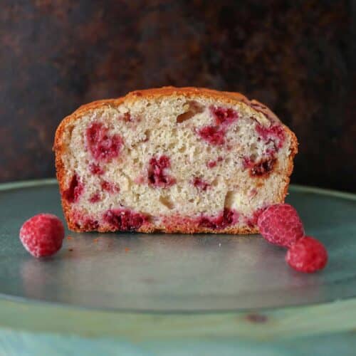 Loaf of raspberry lemon bread that has been cut, showing the interior.