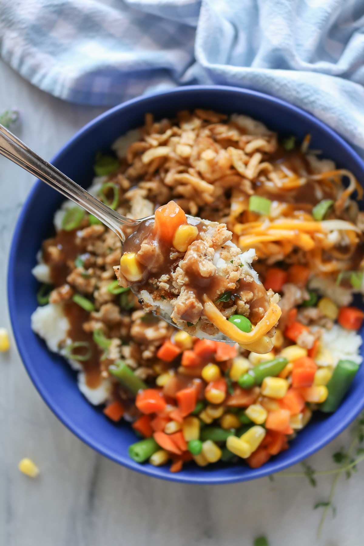 Spoonful of food from a ground chicken mashed potato bowl.