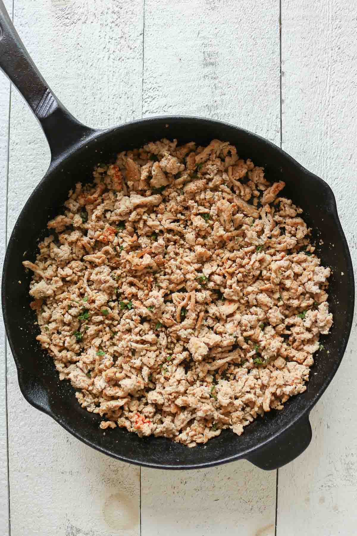 Seasoned cooked ground chicken in a skillet.