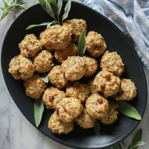 Stuffing chicken meatballs on a black platter.