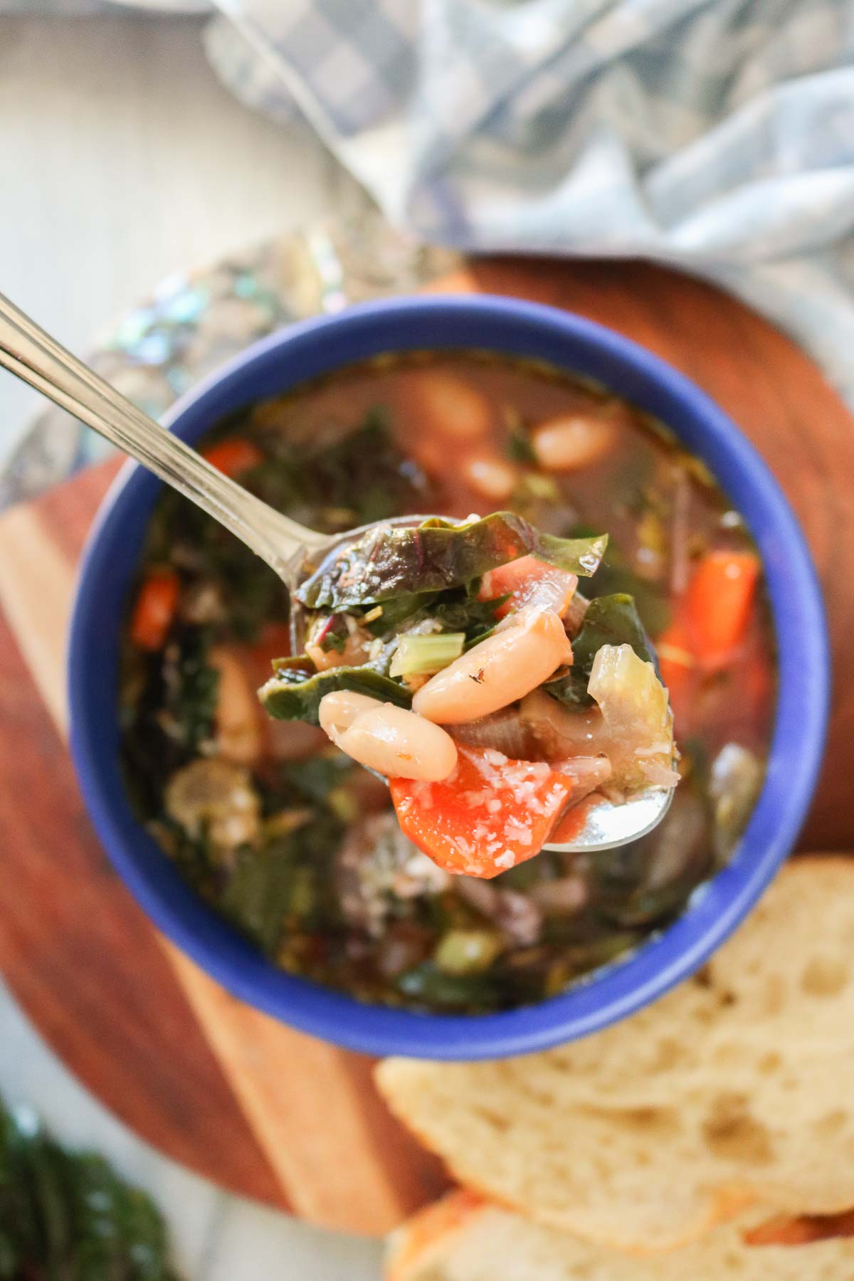 Spoonful of bean and Swiss chard soup from a bowl.