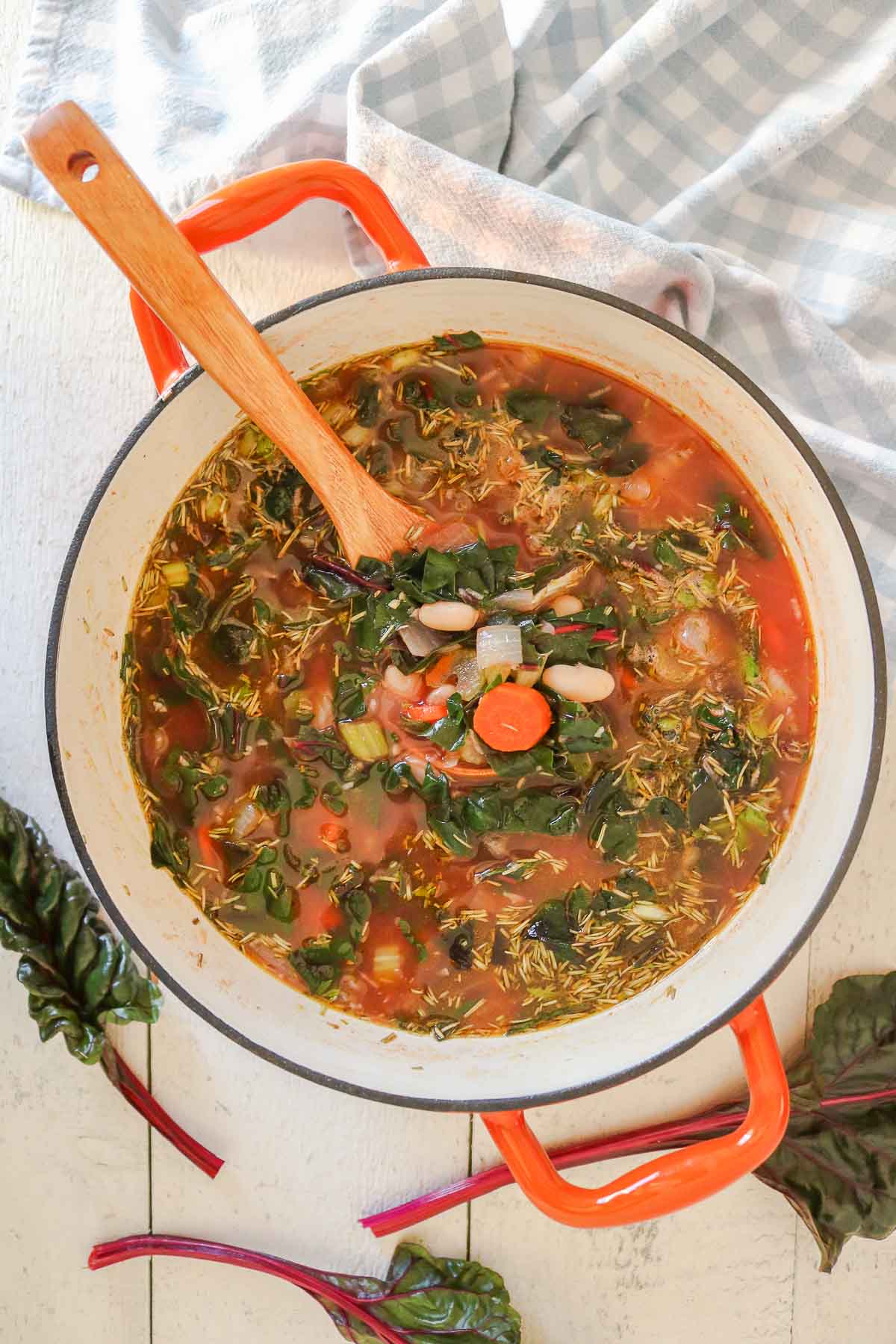 Pot of bean and Swiss chard soup with a serving spoon.
