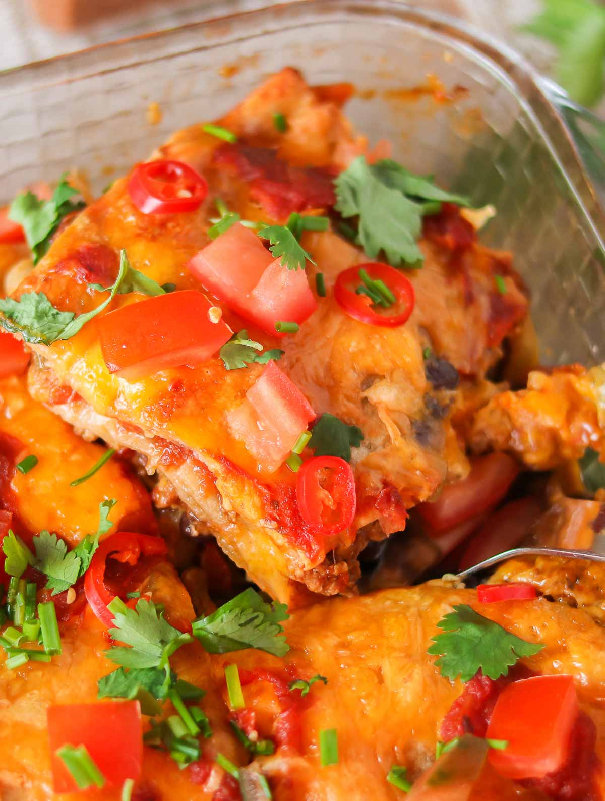 Spatula serving a portion of turkey taco casserole from a baking dish.