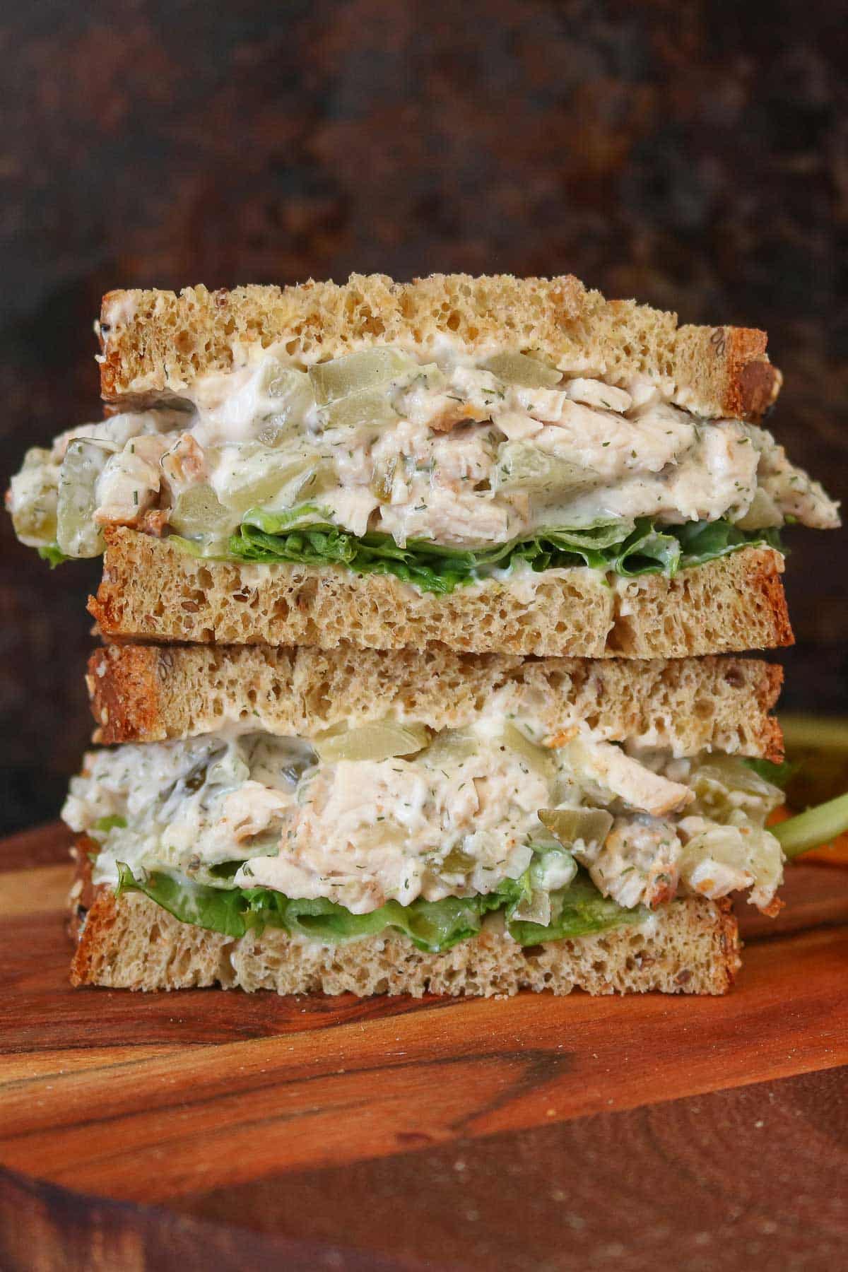 Stack of two halves of a dill pickle turkey salad sandwich.