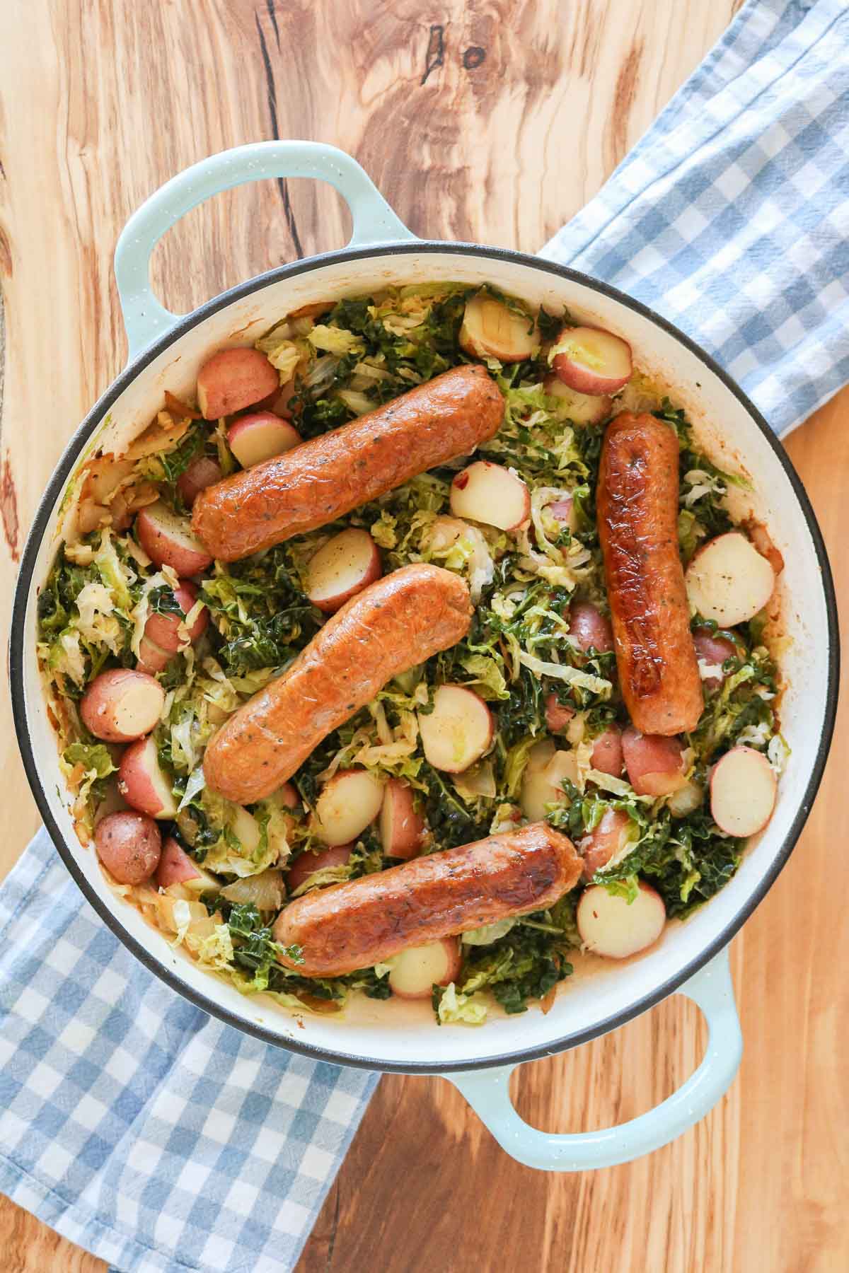 Sauté pan with four sausage, cabbage and potatoes.