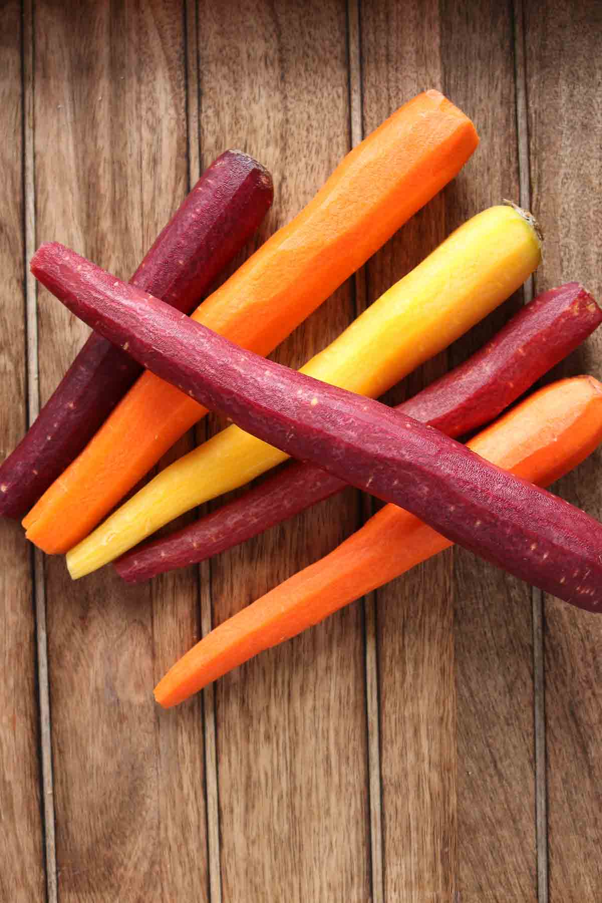 Six peeled rainbow carrots.