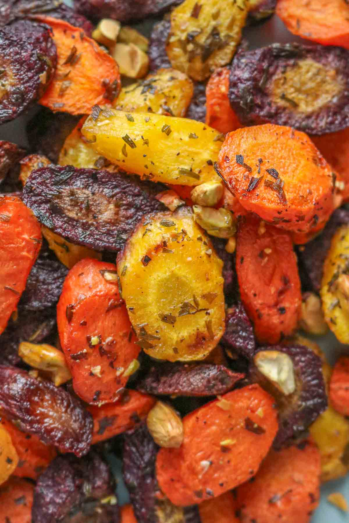 Close-up of roasted rainbow carrots topped with pistachios.